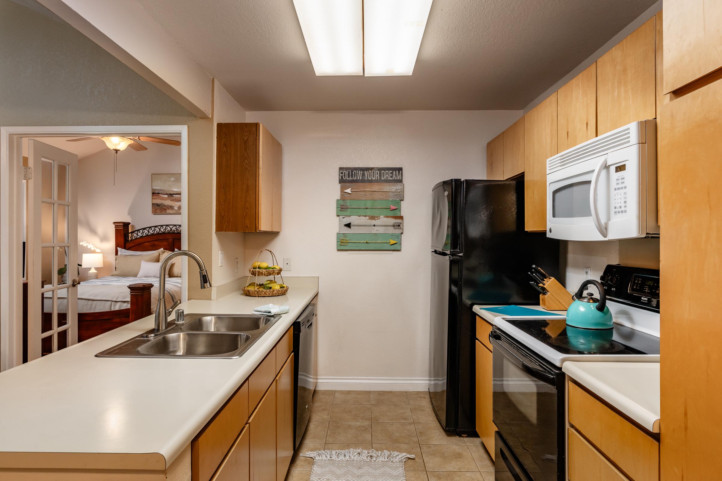 68-3883 Lua Kula Street, Unit 2106 Waikoloa, HI 96738 - Photo 3 of 13 a kitchen with stainless steel appliances granite countertop a sink stove and refrigerator