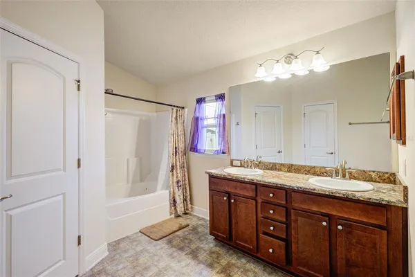 a spacious bathroom with a granite countertop sink a mirror and a shower