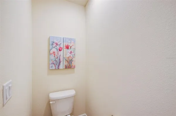 a white toilet sitting next to a white wall