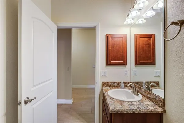 a bathroom with a granite countertop sink and a mirror