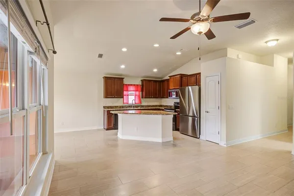 a view of kitchen with refrigerator microwave and stove