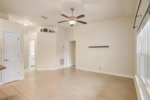 an empty room with closet and a ceiling fan