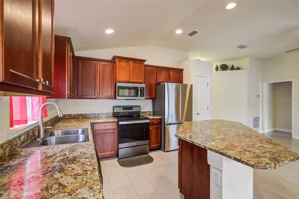 a kitchen with stainless steel appliances granite countertop a sink stove and refrigerator