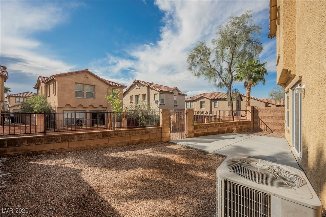 1161 Gecko Road Henderson, NV 89002 - Photo 11 of 54 Back of property featuring a residential view, stucco siding, a gate, and a patio