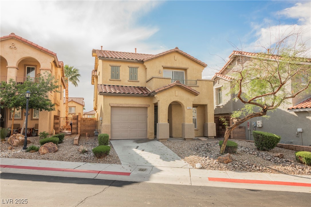 1161 Gecko Road Henderson, NV 89002 - Photo 2 of 54 Mediterranean / spanish house with stucco siding, concrete driveway, a tile roof, a garage, and a balcony
