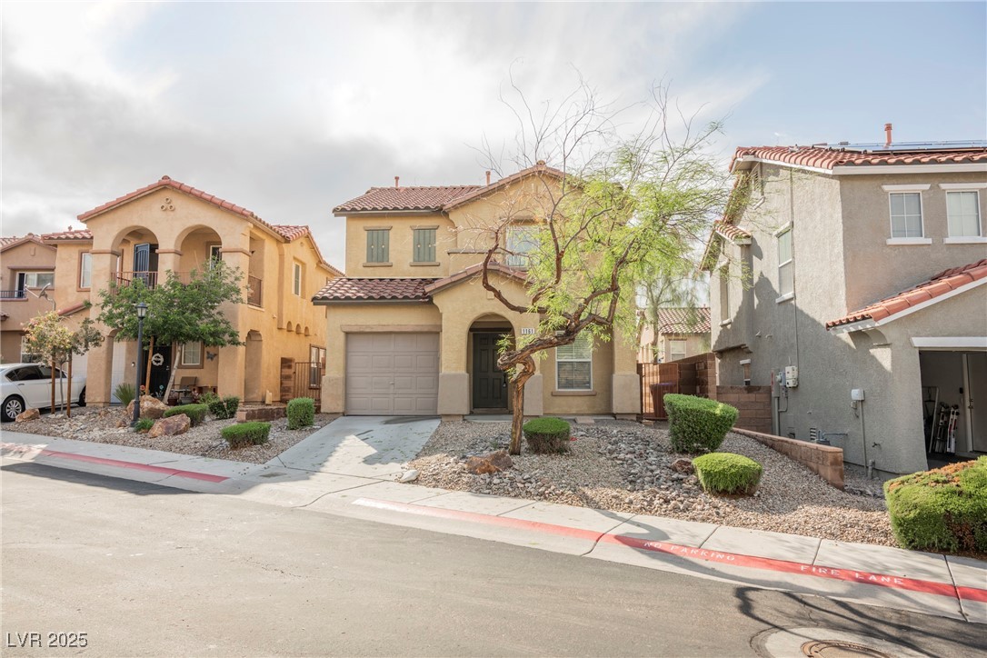1161 Gecko Road Henderson, NV 89002 - Photo 4 of 54 Mediterranean / spanish house featuring stucco siding, a tile roof, an attached garage, and concrete driveway