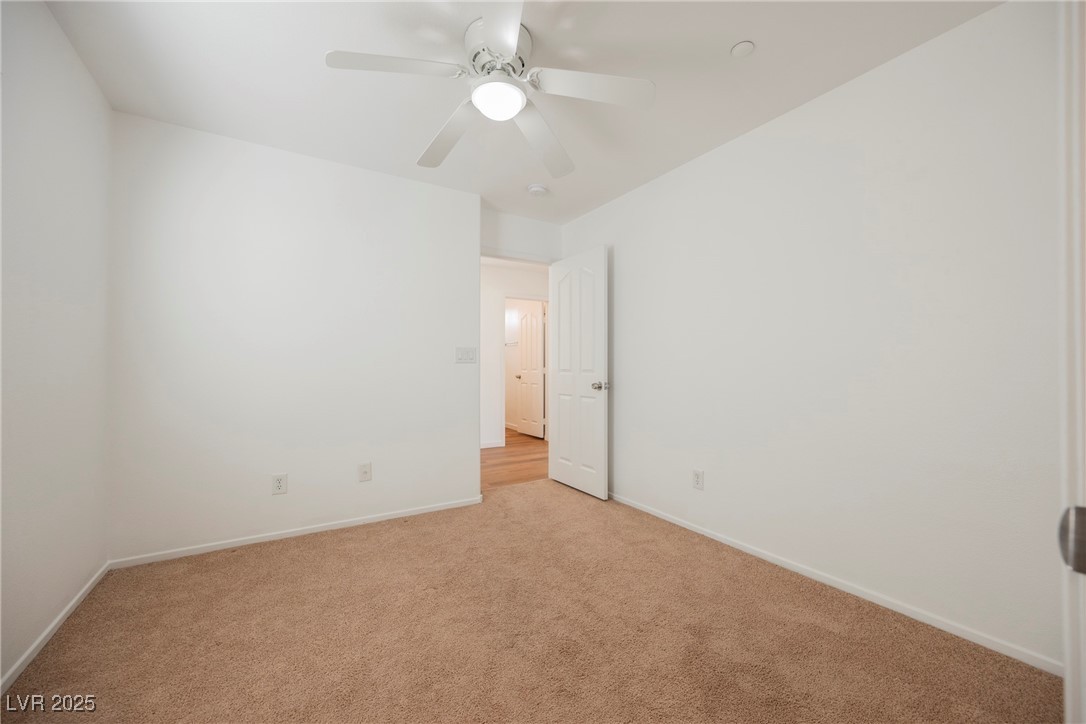 1161 Gecko Road Henderson, NV 89002 - Photo 47 of 54 Empty room with light colored carpet and ceiling fan