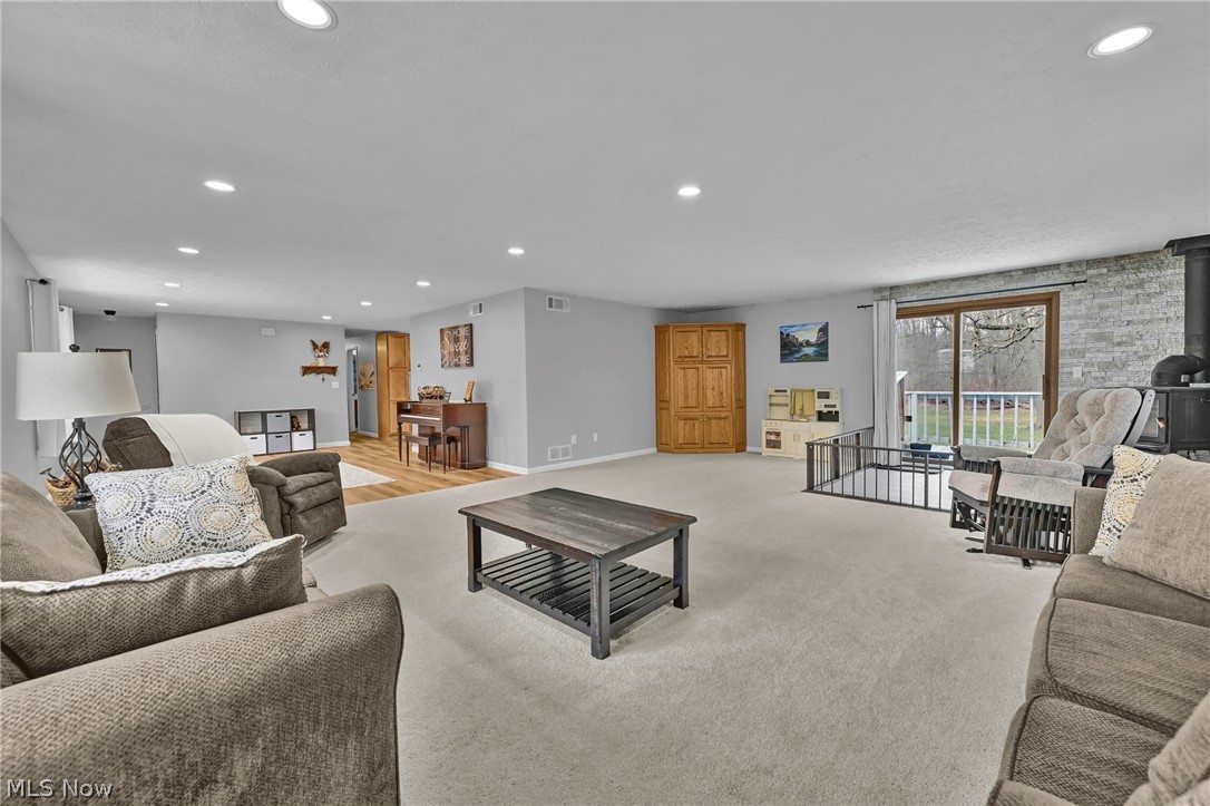 259 East Ohio Avenue Rittman, OH 44270 - Photo 16 of 41 Living room featuring recessed lighting, a wood stove, and light carpet