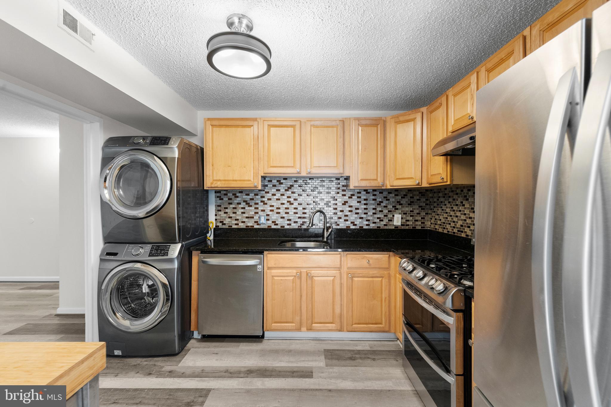 11835 Shire Court, Unit 12C Reston, VA 20191 - Photo 11 of 28 a kitchen with stainless steel appliances granite countertop a stove and a refrigerator
