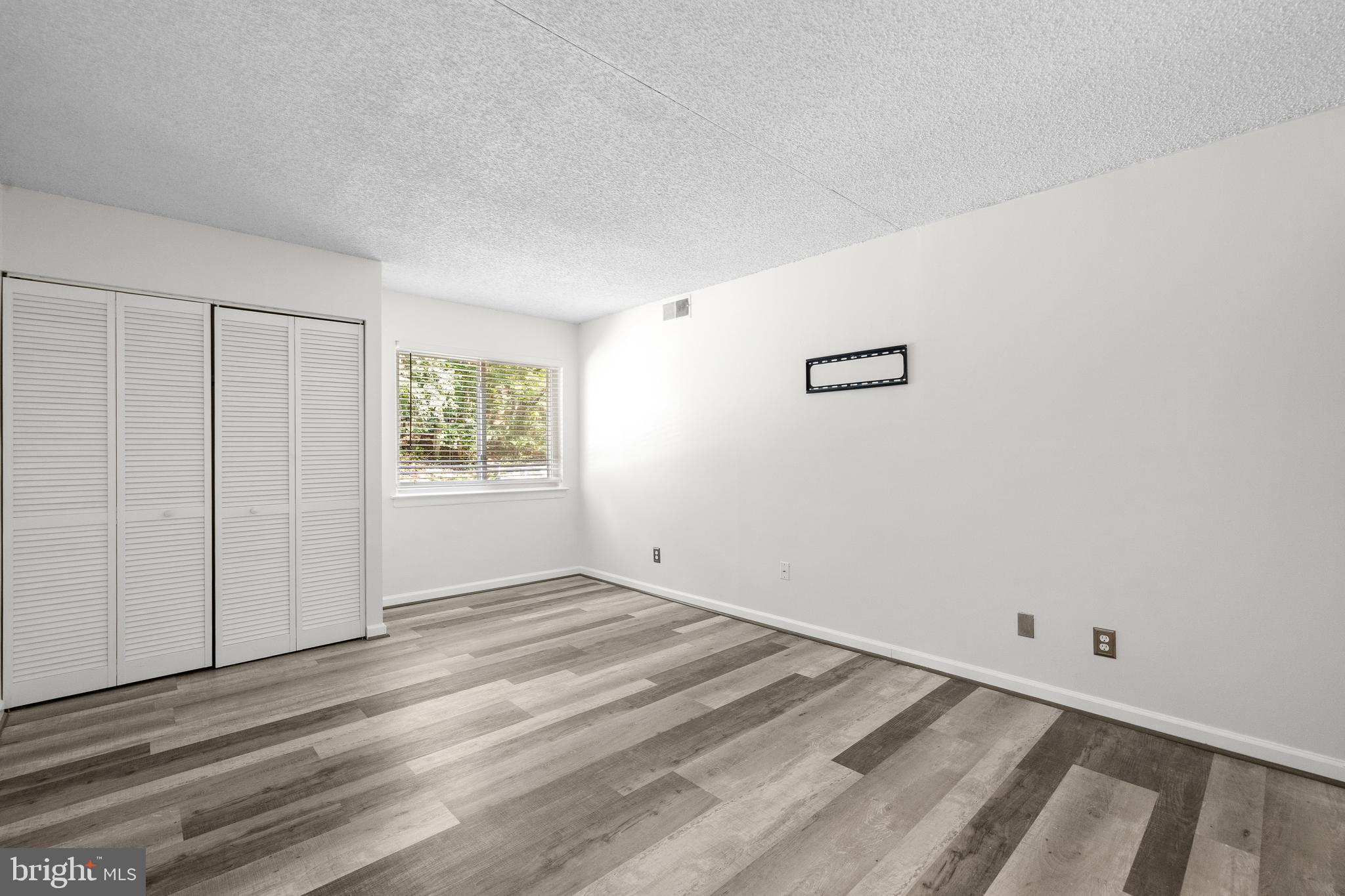 11835 Shire Court, Unit 12C Reston, VA 20191 - Photo 16 of 28 a view of an empty room with wooden floor and a window