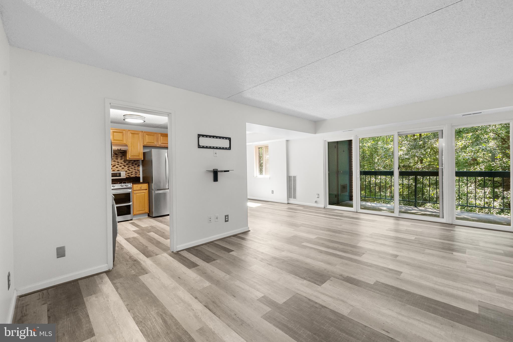 11835 Shire Court, Unit 12C Reston, VA 20191 - Photo 2 of 28 a view of an empty room with wooden floor and a window
