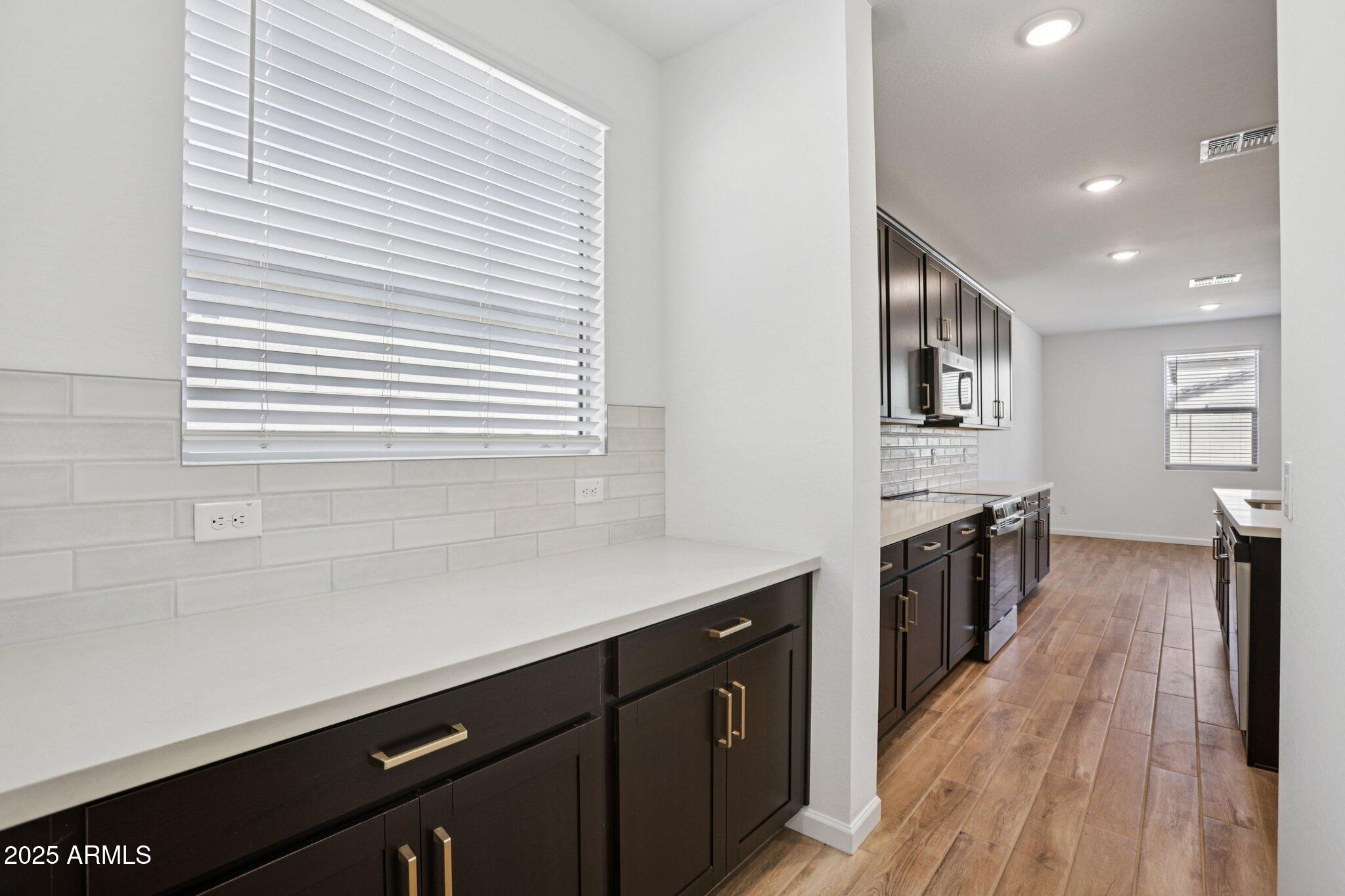 15722 West Brown Street Waddell, AZ 85355 - Photo 14 of 61 a kitchen with a sink stove and cabinets