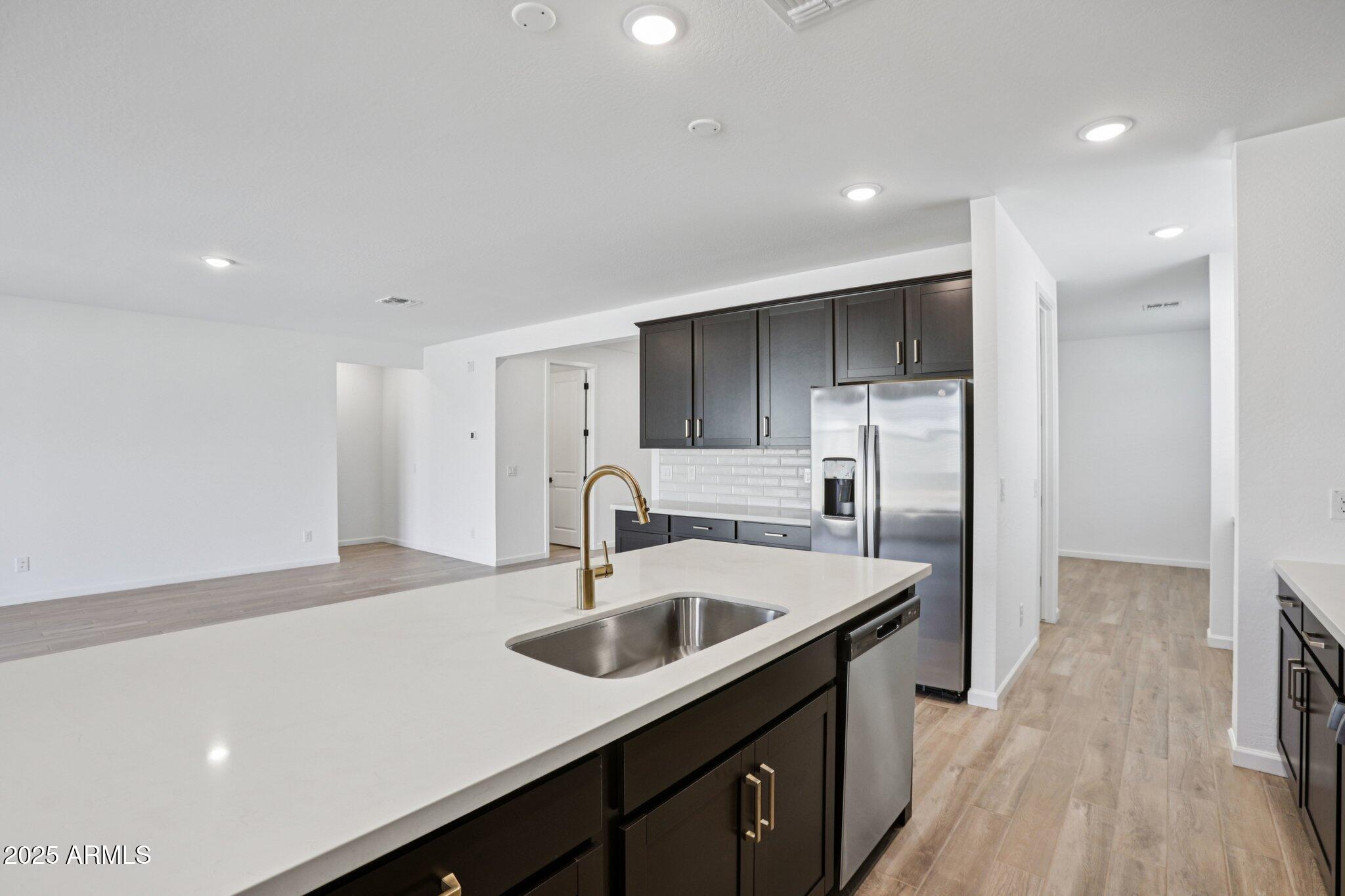 15722 West Brown Street Waddell, AZ 85355 - Photo 16 of 61 a kitchen with kitchen island a sink appliances and cabinets