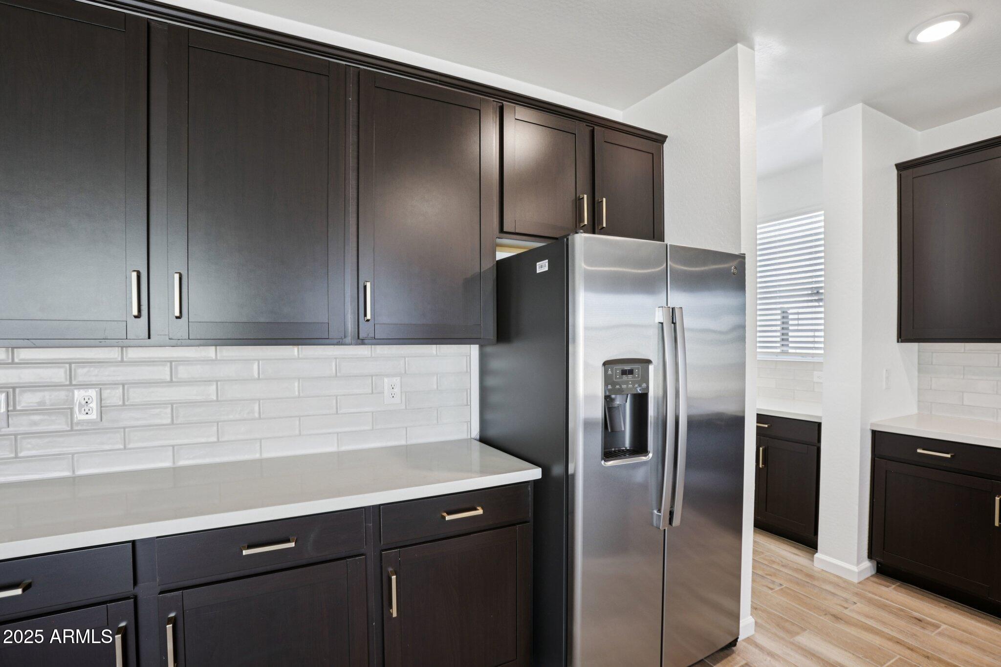 15722 West Brown Street Waddell, AZ 85355 - Photo 18 of 61 a kitchen with a refrigerator and a sink