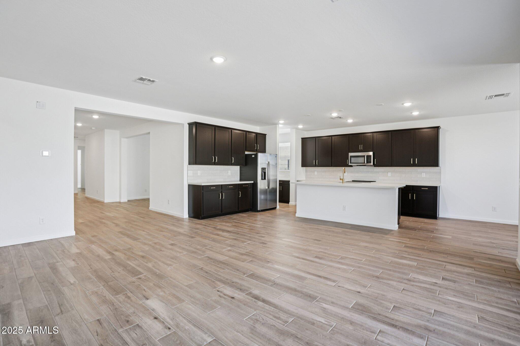 15722 West Brown Street Waddell, AZ 85355 - Photo 6 of 61 a view of a kitchen with a sink and a stove top oven