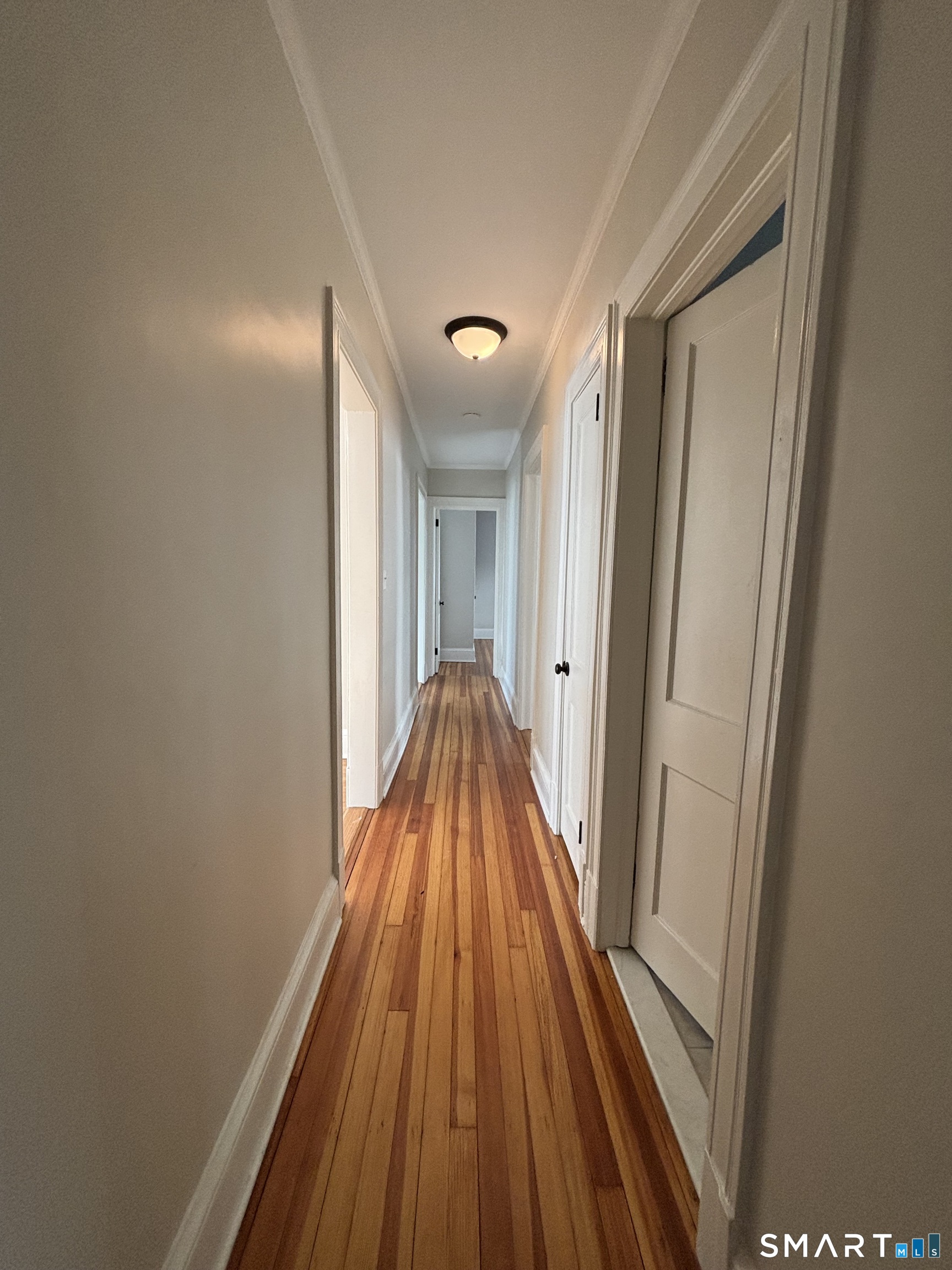 9 Bretton Road, Unit 2 West Hartford, CT 06119 - Photo 11 of 17 a view of a hallway with wooden floor and staircase
