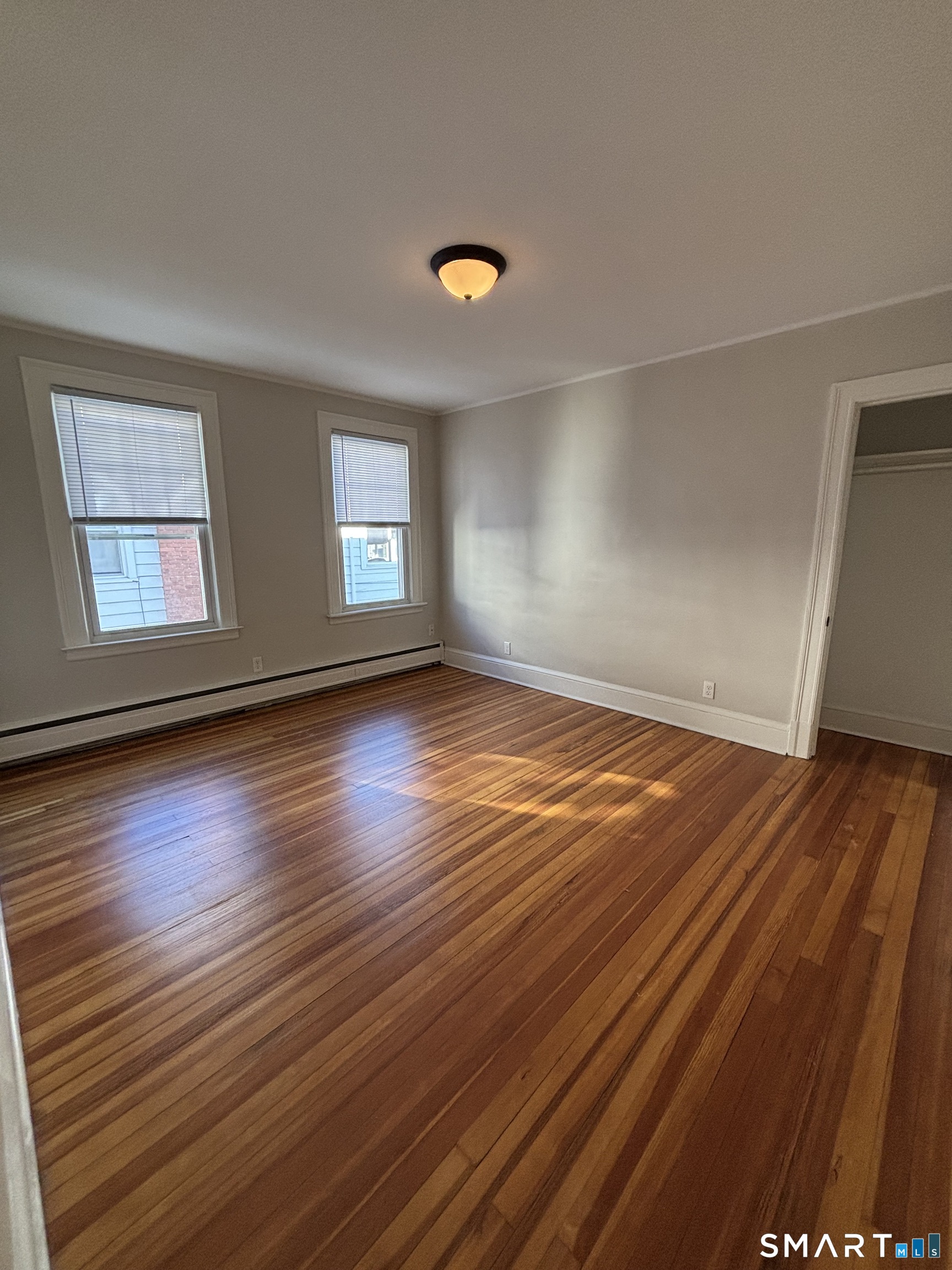 9 Bretton Road, Unit 2 West Hartford, CT 06119 - Photo 12 of 17 an empty room with wooden floor and windows