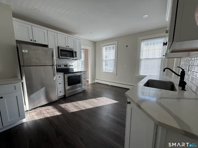 a kitchen with a sink a microwave a refrigerator and cabinets
