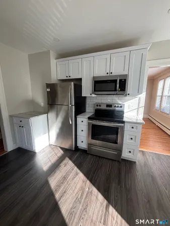a kitchen with wooden floors a refrigerator and a stove