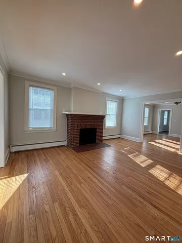 a view of empty room with wooden floor and fireplace