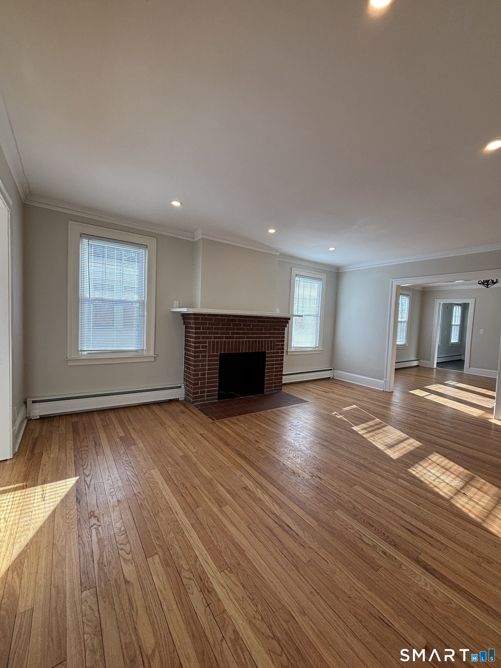 9 Bretton Road, Unit 2 West Hartford, CT 06119 - Photo 8 of 17 a view of empty room with wooden floor and fireplace
