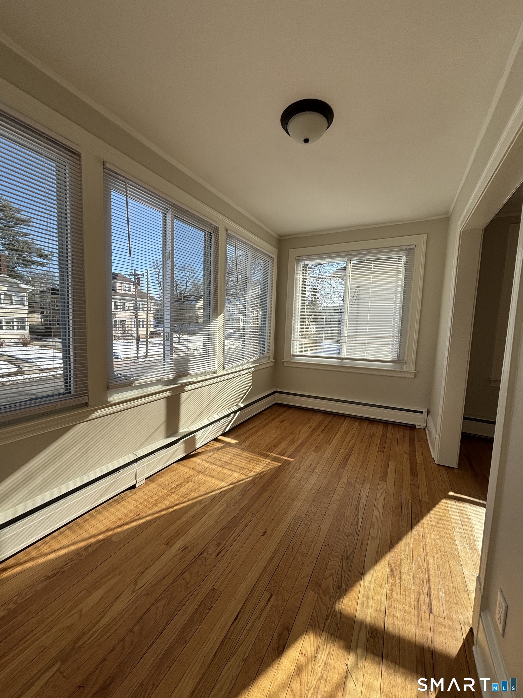 9 Bretton Road, Unit 2 West Hartford, CT 06119 - Photo 9 of 17 a view of an empty room with wooden floor and a window