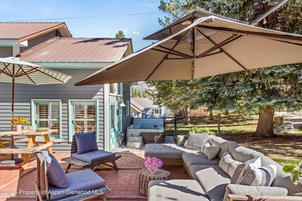 a view of a patio with a table and chairs under an umbrella