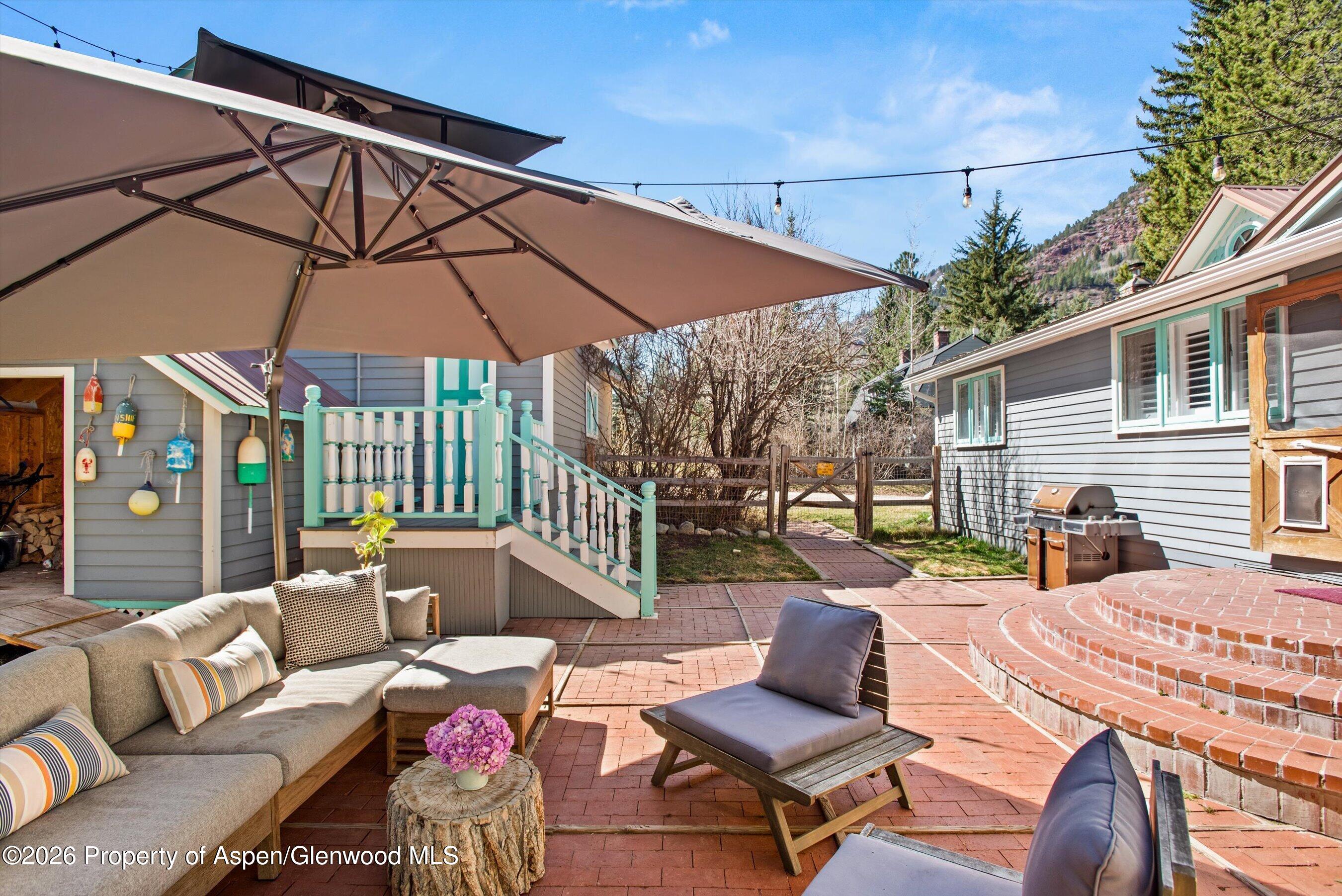244 Redstone Boulevard Redstone, CO 81623 - Photo 4 of 55 a view of a patio with a table and chairs under an umbrella