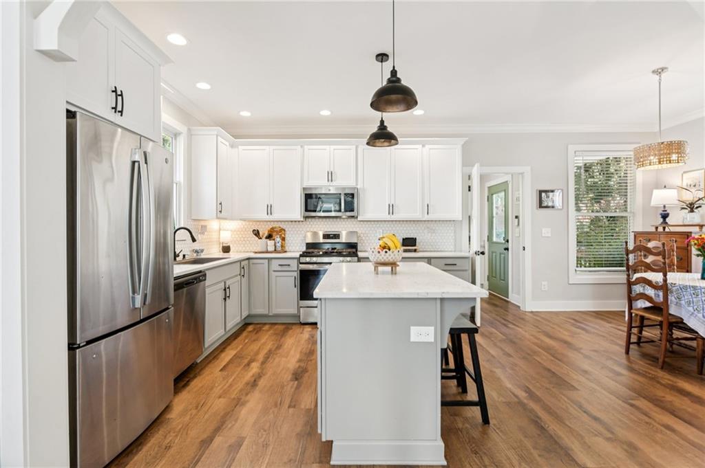 406 Bell Street Monroe, GA 30655 - Photo 12 of 60 a kitchen with stainless steel appliances a refrigerator a stove a sink dishwasher a oven with white cabinets and wooden floor