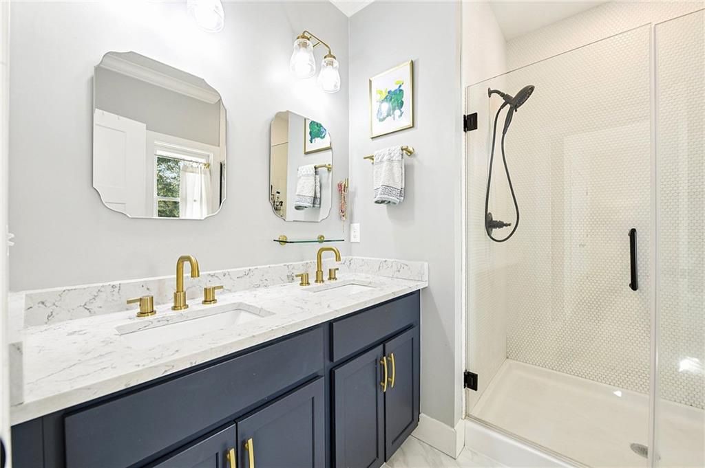 406 Bell Street Monroe, GA 30655 - Photo 29 of 60 a bathroom with a granite countertop sink mirror and a shower