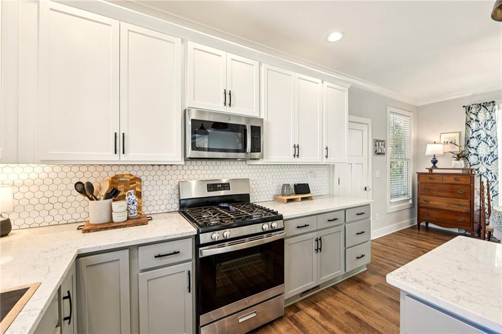 406 Bell Street Monroe, GA 30655 - Photo 9 of 60 a kitchen with stainless steel appliances a stove sink microwave and cabinets