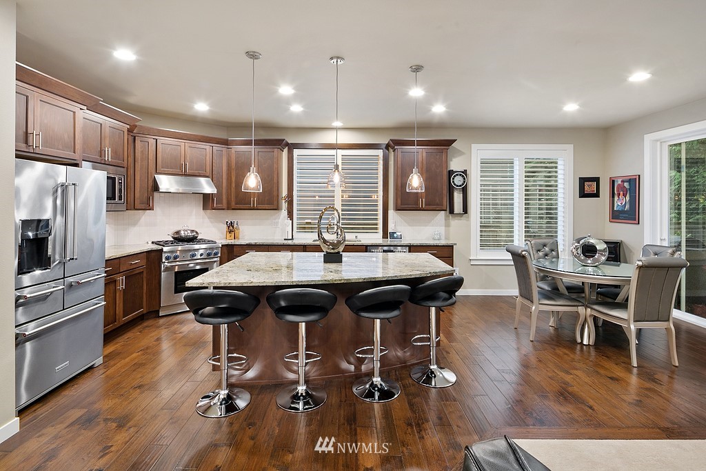 21920 37th Avenue Southeast Bothell, WA 98021 - Photo 11 of 39 a kitchen with a table chairs refrigerator and cabinets