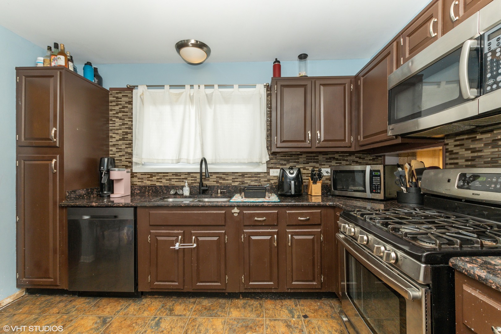 5746 Timberlane Road Matteson, IL 60443 - Photo 6 of 19 a kitchen with granite countertop a stove top oven microwave and cabinets