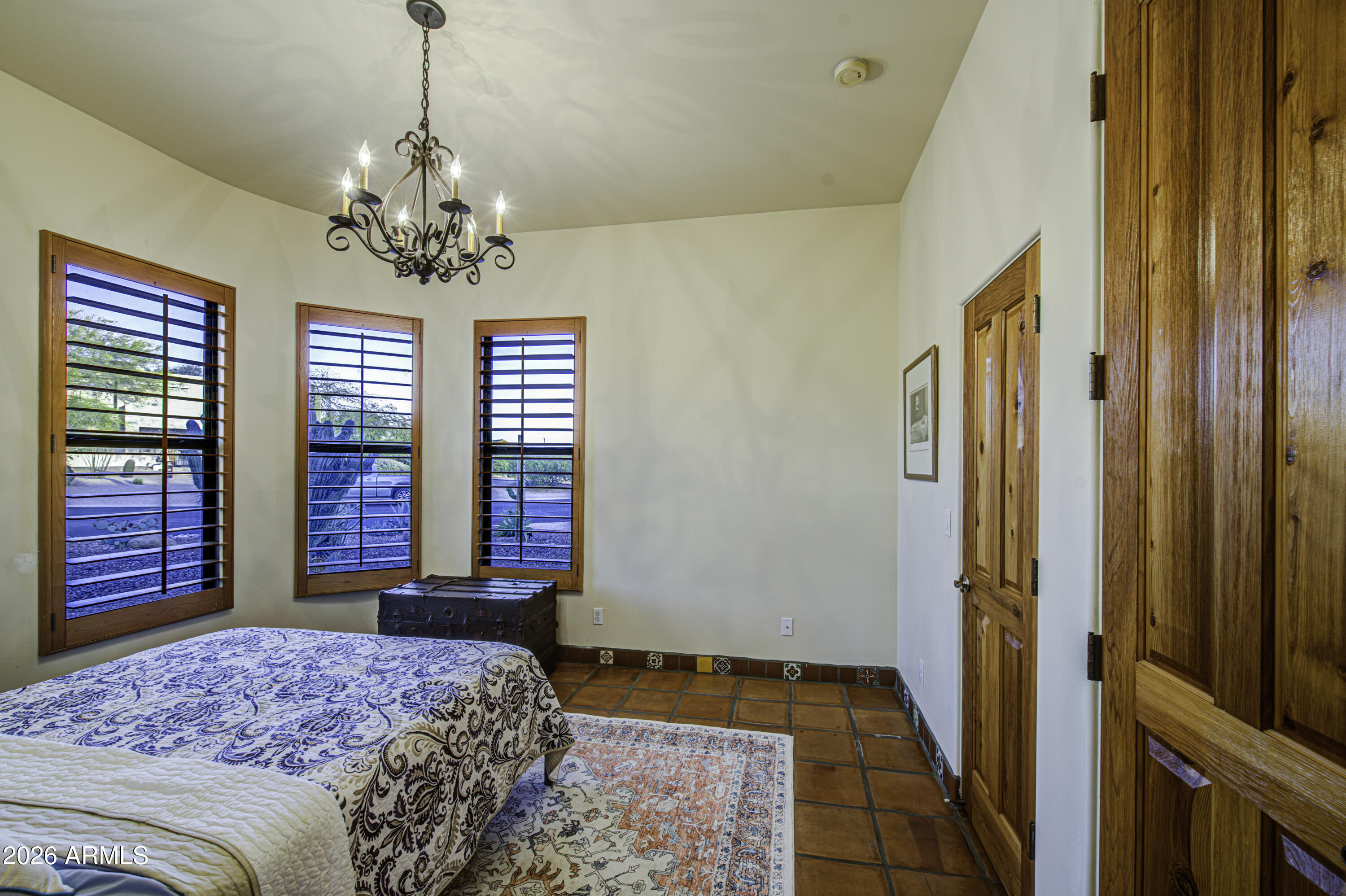 8540 East McDowell Road, Unit 122 Mesa, AZ 85207 - Photo 31 of 75 a bedroom with a large bed and a chandelier