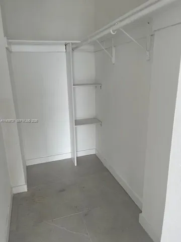 a kitchen with stainless steel appliances granite countertop a refrigerator a sink and white cabinets