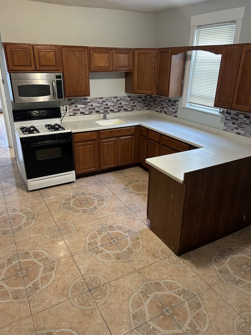 3718 North Spaulding Avenue Chicago, IL 60618 - Photo 11 of 18 a kitchen with stainless steel appliances a stove a sink and a microwave