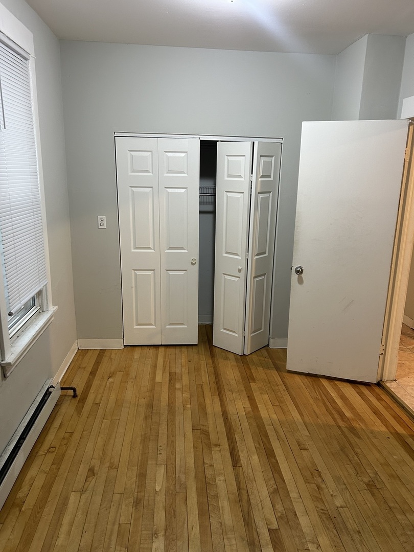 3718 North Spaulding Avenue Chicago, IL 60618 - Photo 18 of 18 a view of an empty room with wooden floor and a window