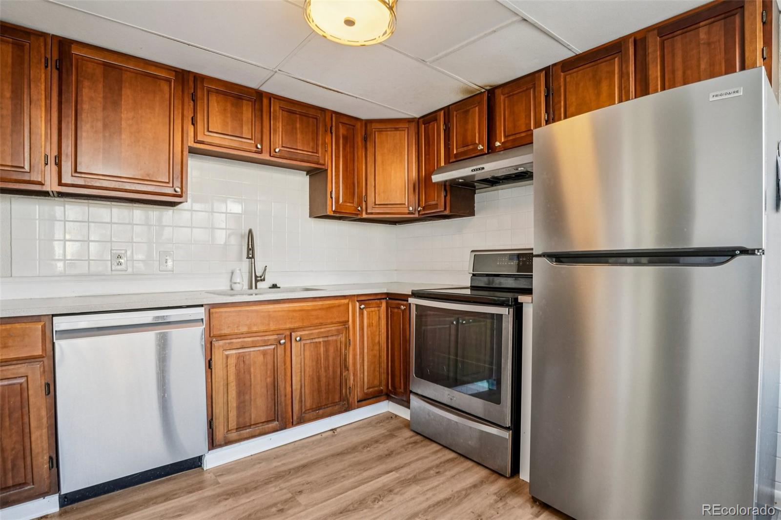 10095 West 35th Avenue Wheat Ridge, CO 80033 - Photo 11 of 50 a kitchen with stainless steel appliances granite countertop a refrigerator sink and cabinets