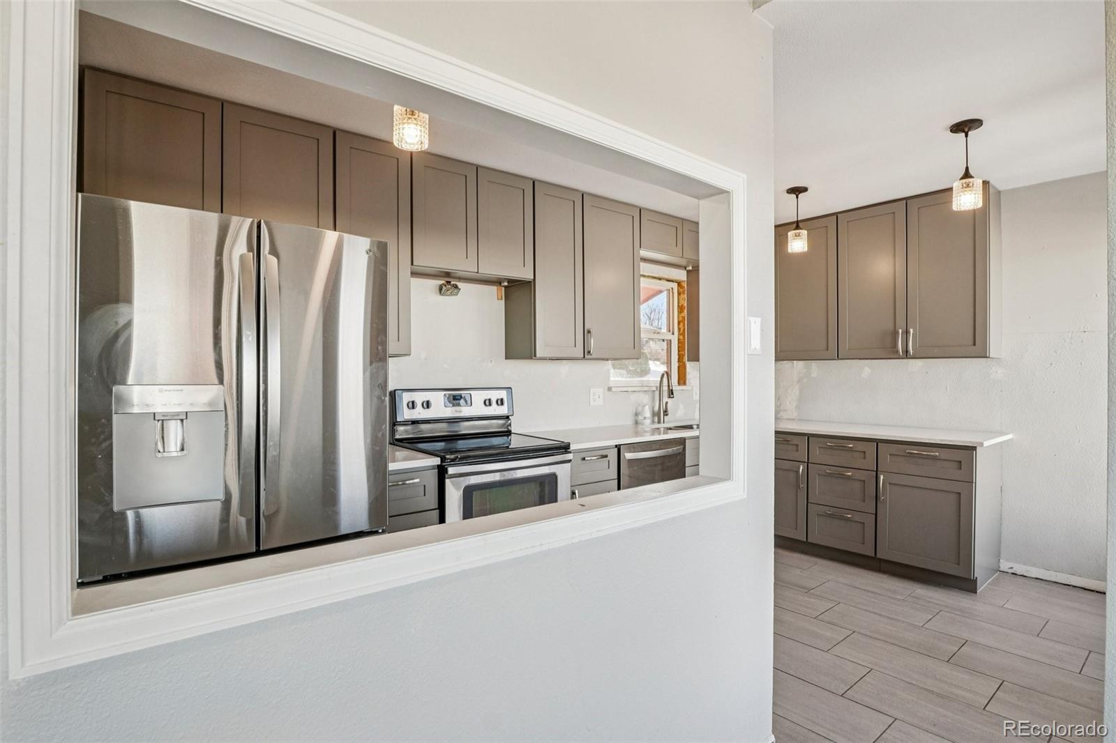 10095 West 35th Avenue Wheat Ridge, CO 80033 - Photo 14 of 50 a kitchen with stainless steel appliances a refrigerator stove and sink