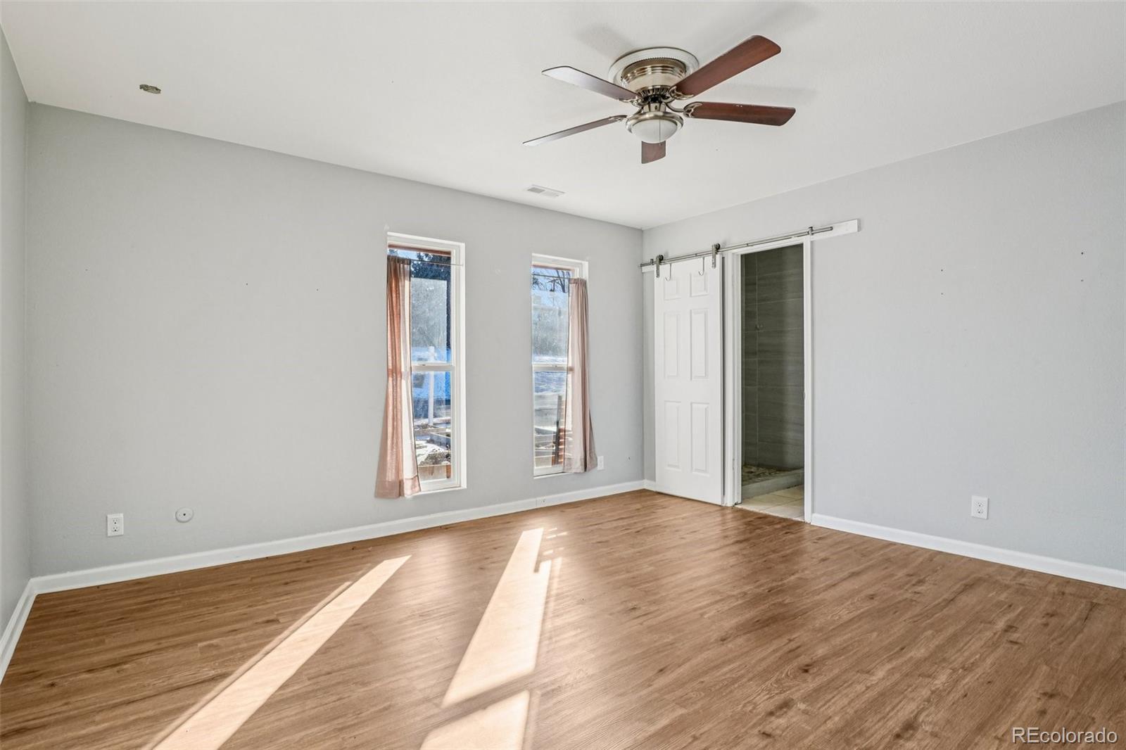10095 West 35th Avenue Wheat Ridge, CO 80033 - Photo 21 of 50 a view of an empty room with window and wooden floor