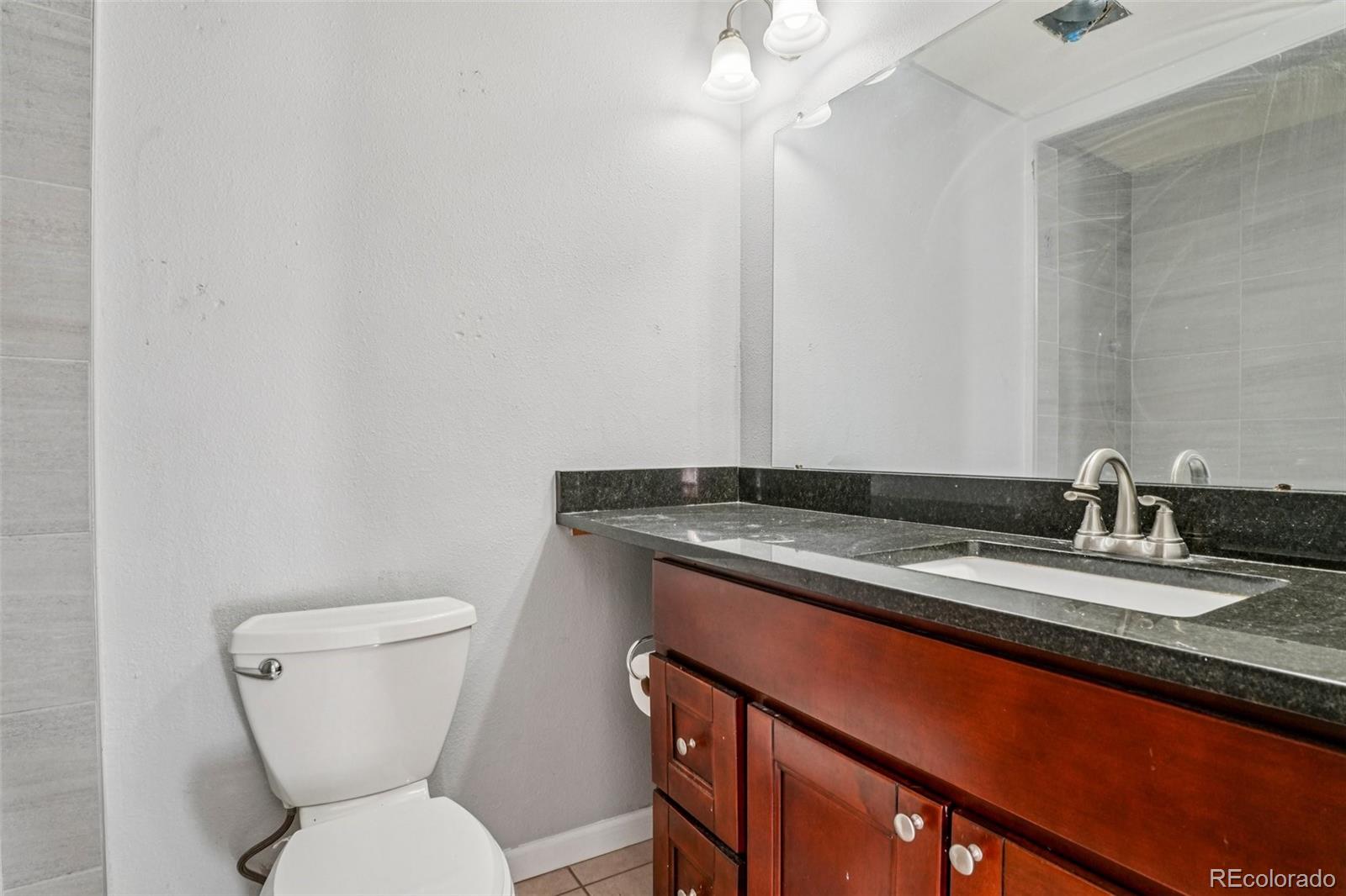 10095 West 35th Avenue Wheat Ridge, CO 80033 - Photo 22 of 50 a bathroom with a granite countertop toilet sink and mirror