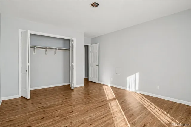 a view of empty room with wooden floor
