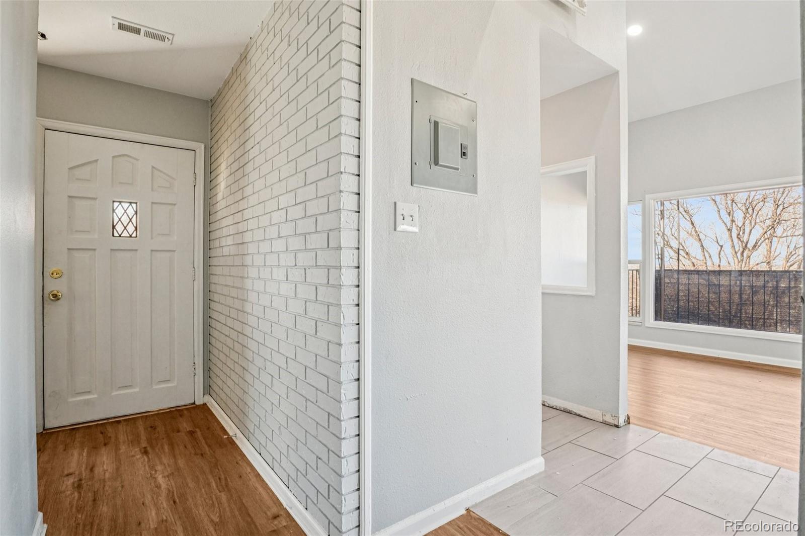 10095 West 35th Avenue Wheat Ridge, CO 80033 - Photo 3 of 50 a view of a hallway with wooden floor and a bathroom