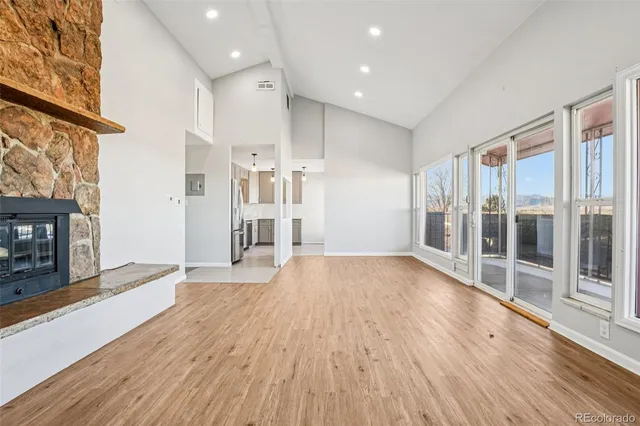 a view of empty room with wooden floor and fireplace