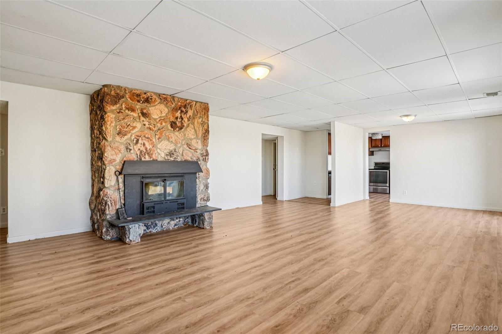 10095 West 35th Avenue Wheat Ridge, CO 80033 - Photo 9 of 50 a view of empty room with wooden floor and fireplace
