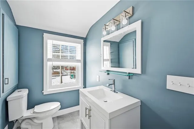 a bathroom with a toilet sink and mirror