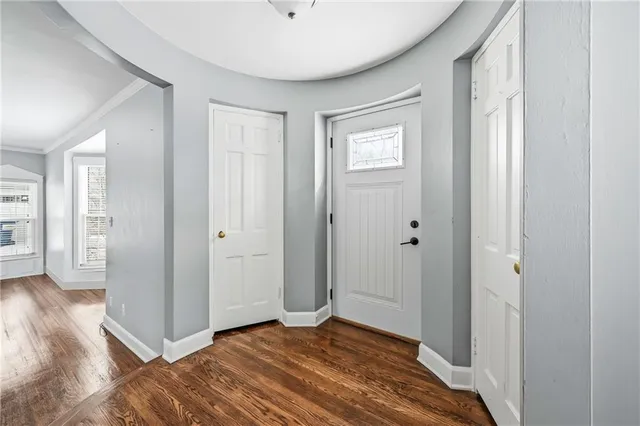 a view of a livingroom with wooden floor and a bathroom