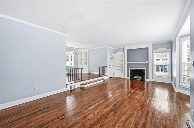 wooden floor fireplace and windows in an empty room