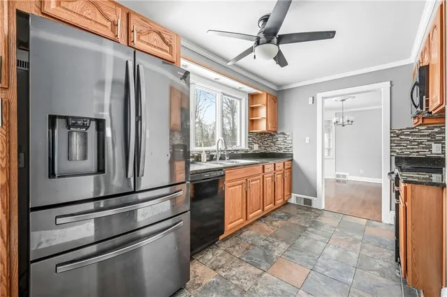 a kitchen with stainless steel appliances granite countertop a refrigerator and a stove