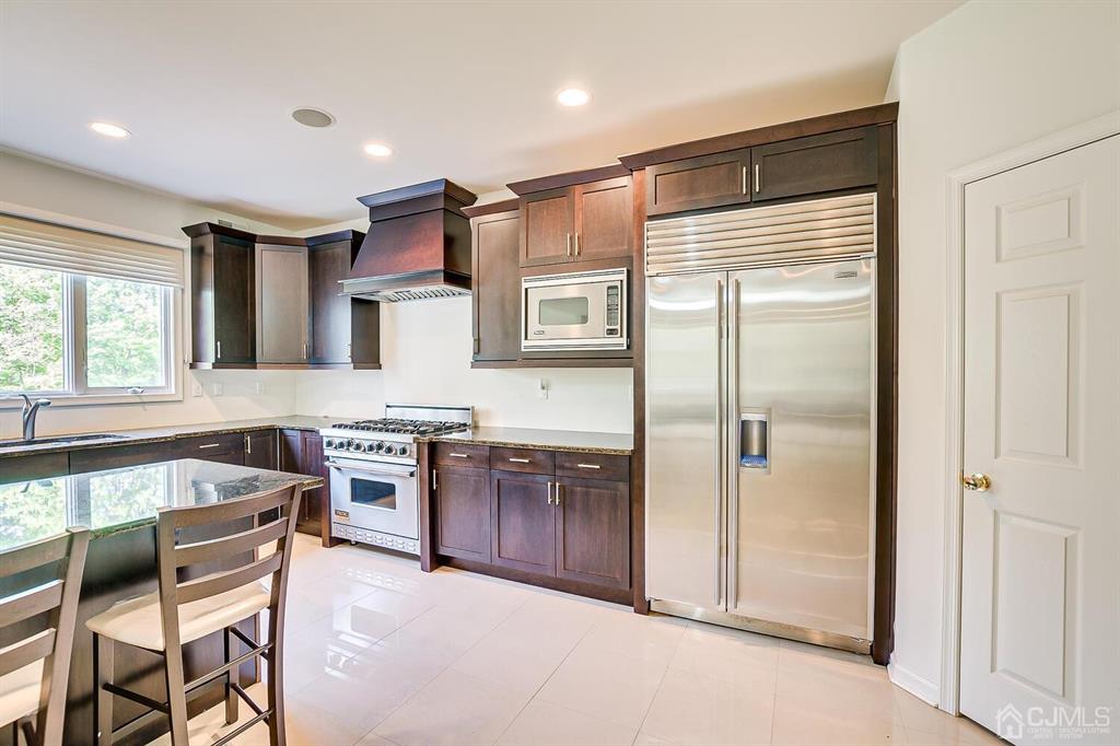 12 Hayduk Drive Edison, NJ 08820 - Photo 35 of 64 a kitchen with stainless steel appliances granite countertop a refrigerator and wooden cabinets